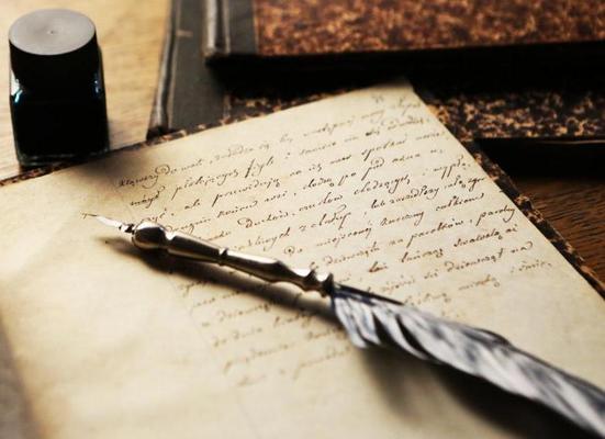 An image of a quill, ink bottle and paper